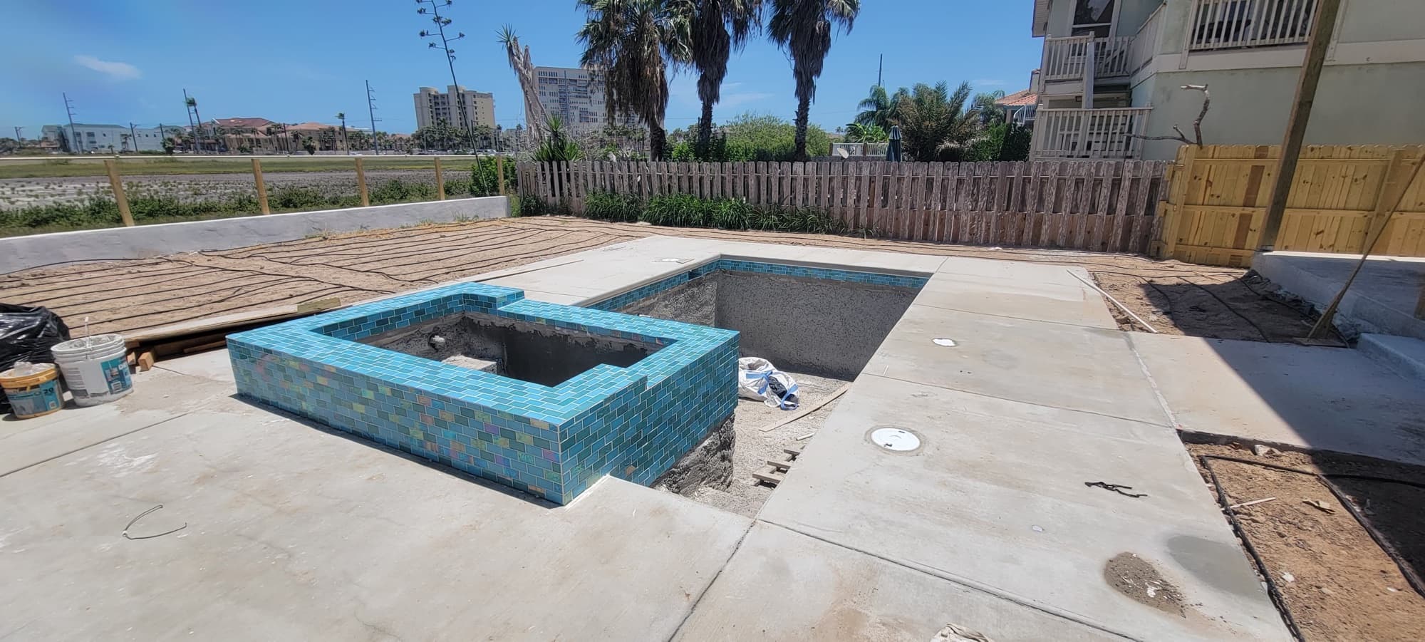Waterline tile being installed around the pool and spa