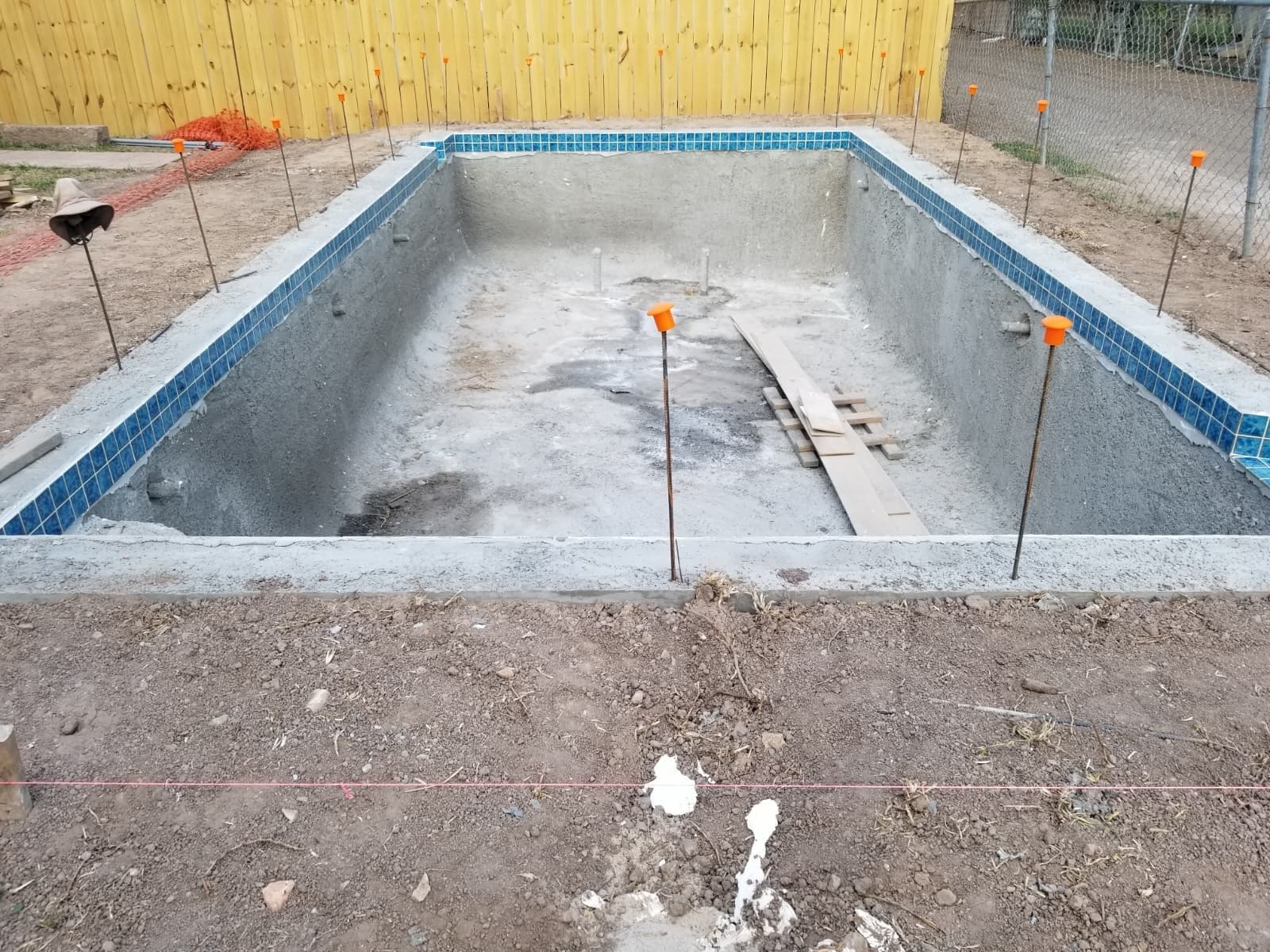 Waterline tile being installed around the pool and spa