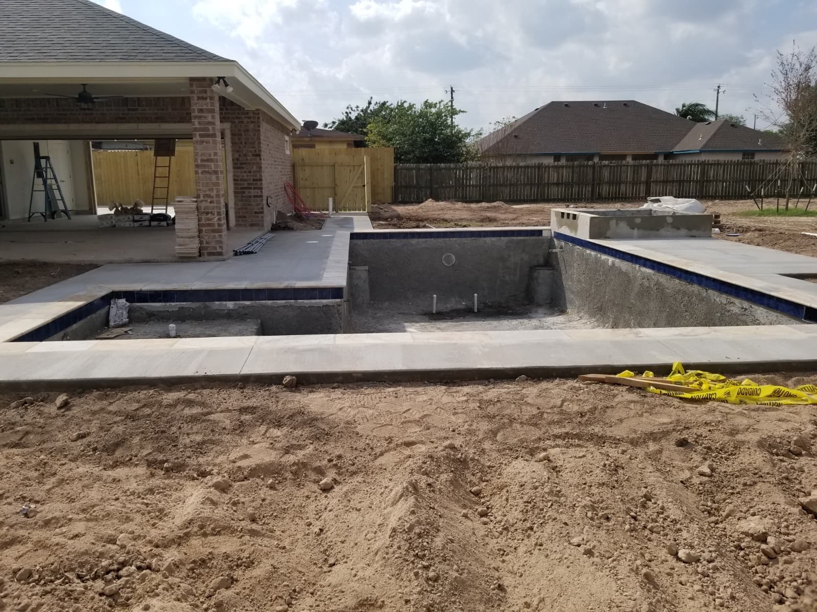 Waterline tile being installed around the pool and spa